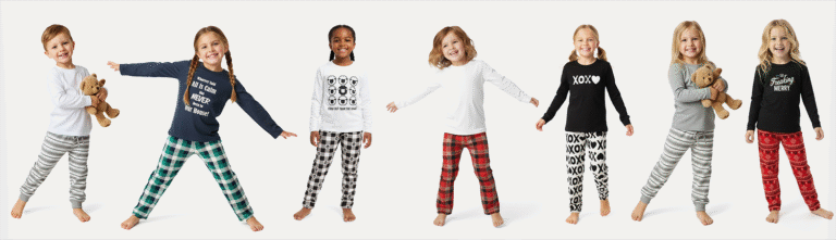 Group of smiling children modeling playful holiday pajamas with bold graphic prints, including plaids, sheep, "XOXO" patterns, and festive messages—each child showcasing a different outfit in coordinated top-and-bottom sets.